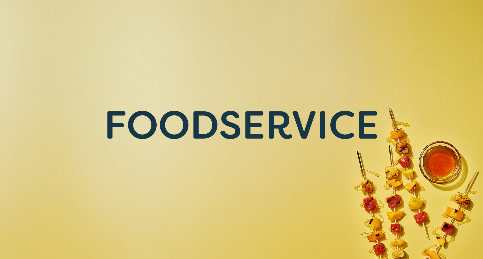 Foodservice text on yellow background with fruit and meat skewers drizzled with honey next to a small bowl of honey.
