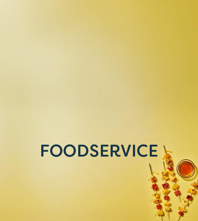 Foodservice text on yellow background with fruit and meat skewers drizzled with honey next to a small bowl of honey.